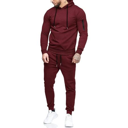 A man in maroon hoodie and pants standing next to each other.